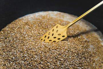 Adding malt to water for sweetening process, closeup. High quality photo