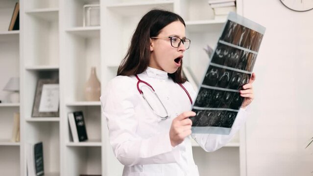 Portrait of shocked surprised scared woman doctor therapist with glasses found something weird in diagnosis while looking at results patient MRI or CT scan procedure at office