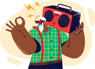 Gray-haired dark-skinned old man with tape recorder on shoulder smiles and shows OK gesture