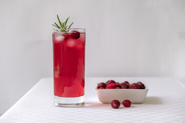 Cranberry juice in a glass on a table with a white tablecloth