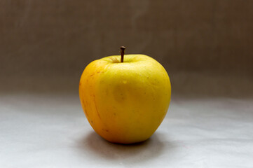 One yellow apple on the table