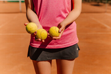 Caucasian woman hold yellow green balls, playing tennis match on clay court surface on weekend free time sunny day. Female player ready to serve, wear skort. Professional sport concept
 - obrazy, fototapety, plakaty