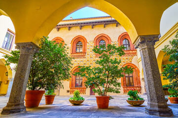 The view through the arcades of Palazzo Borromeo on the medieval frescoes on the inner wall of the palace, Milan, Italy
