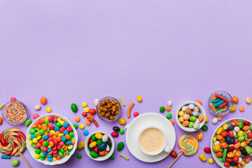 Fototapeta na wymiar Coffee cup with chocolates and colored candy. Top view on table background with copy space