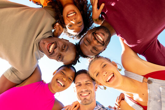 Portrait of happy diverse friends embracing and smiling at beach, with copy space