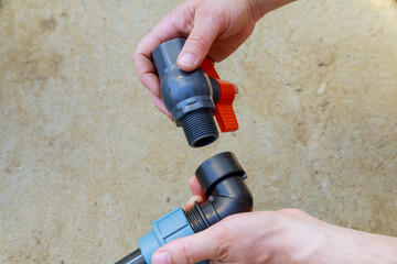 A plumber installs a ball valve for water on a polyethylene pipe. Installation of the irrigation...