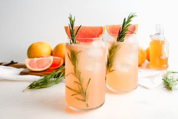 Honey Rosemary Grapefruit Sodas Garnished with Red Grapefruit: Nonalcoholic sodas served in can-shaped glasses with ice cubes