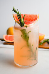 Honey Rosemary Grapefruit Soda Garnished with Red Grapefruit: Nonalcoholic soda served in can-shaped glasses with ice cubes