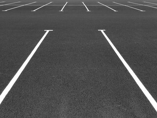 Fototapeta na wymiar Marking road lines in parking lot. Parking markings, black and white stripes on bitumen. Parking place at store. Empty parking lot.