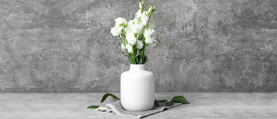 Vase with white eustoma flowers on grunge background