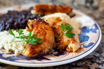 Rice and beans with grilled chicken on plate close up - frango grelhado 