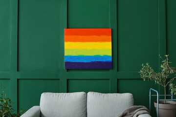 Painting of LGBT flag hanging on green wall in living room