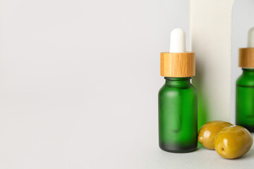 Bottle of essential olive oil on white background