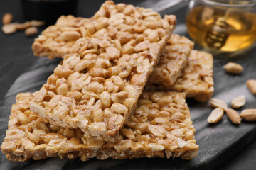 Delicious peanut bars (kozinaki) on black table, closeup