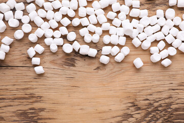 Fototapeta na wymiar Delicious marshmallows on wooden table, flat lay. Space for text