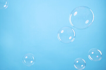 Many beautiful soap bubbles on light blue background. Space for text