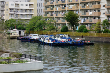 東京の水辺の運河に停泊する漁船の静かな光景