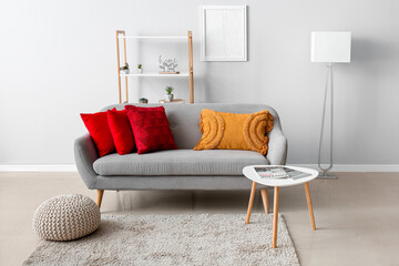 Interior of modern living room with stylish pillows on grey sofa