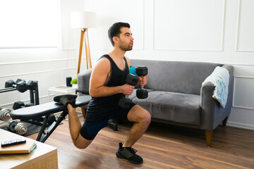 Fototapeta premium Attractive man in his 20s working out in the living room