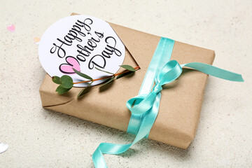 Card with text HAPPY MOTHER'S DAY and beautiful gift box on light background