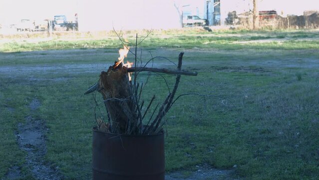 Young Man Tending Trash Can Fire in Rural Tennessee USA BMPC4K