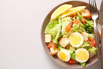 Plate of delicious salad with boiled eggs and salmon on grey background