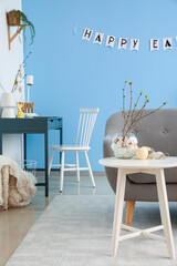 Interior of living room with sofa, workplace and Easter decor