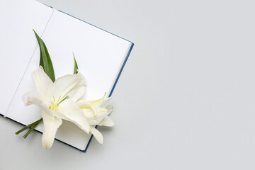 Open book and beautiful lily flowers on white background