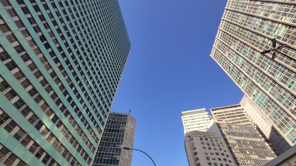 Topo de conjunto de prédios com céu azul ao fundo 