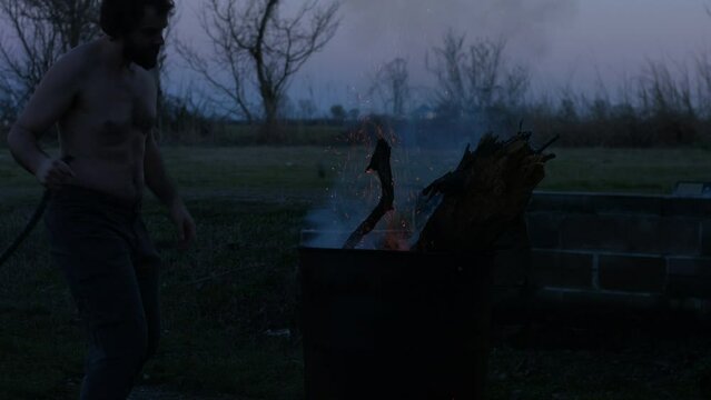 Young Man Tending Trash Can Fire in Rural Tennessee USA BMPC4K