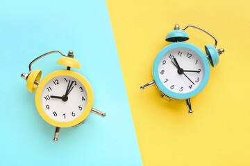 Alarm clocks on blue and yellow background