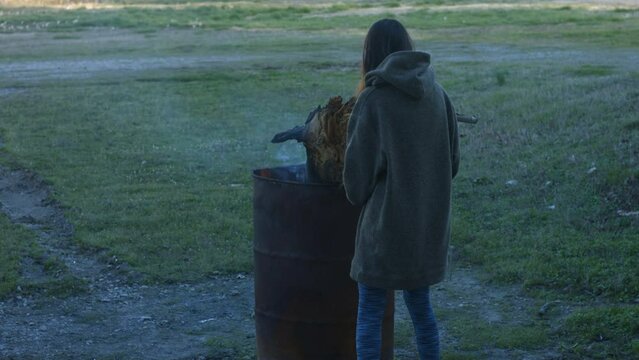 Young Woman Tends To Trashcan Fire In Rural America Countryside BMPC4K