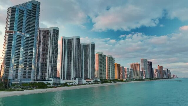 View from above of luxurious highrise hotels and condos on Atlantic ocean shore in Sunny Isles Beach city in the evening. American tourism infrastructure in southern Florida