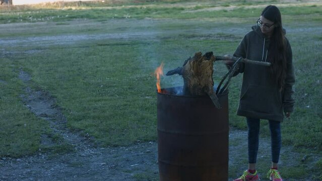 Young Woman Tends To Trashcan Fire In Rural America Countryside BMPC4K