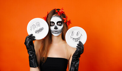 Photo of a girl in Halloween makeup and flower holding some Halloween cartoons.