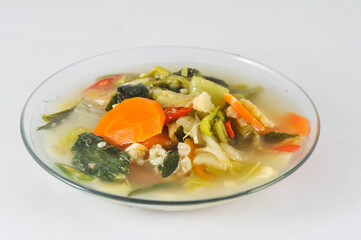 Cap cay, a typical Chinese-Indonesian dish, consists of various vegetables including mustard greens, cauliflower, carrots, served on a small plate isolated on a white background