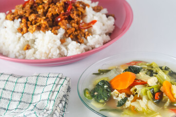 Cap cay, consists of various vegetables including mustard greens, cauliflower, carrots, served on a small plate and white rice with stir-fried sliced tempe, a napkin