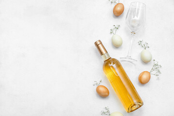 Composition with bottle of wine, glass, Easter eggs and gypsophila flowers on light background