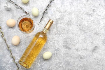 Composition with bottle of wine, glass and Easter eggs on light background