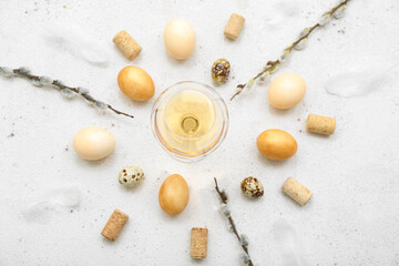 Composition with glass of wine, Easter eggs, willow branches and corks on light background
