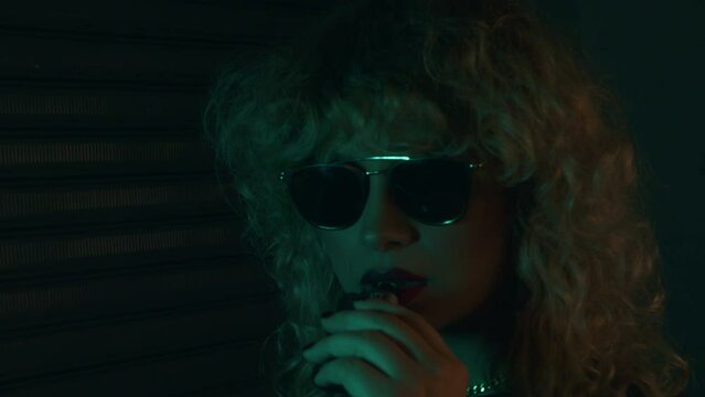 woman in sunglasses  smoking vapear 