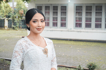 A young Indonesian woman with a happy successful expression wearing a white kebaya. Kartini's Day...