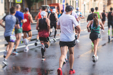 Marathon runners crowd, participants start running the half-marathon in the city streets, crowd of...