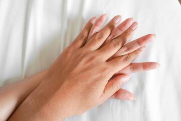 A photo of a man and woman's hands having sex on a bed. make love.