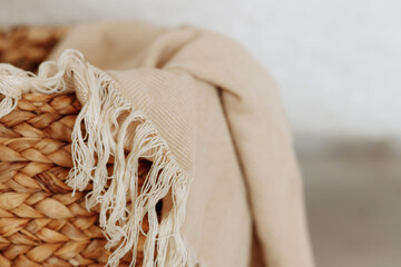 Beautiful beige linen fabric rests inside a rustic woven basket. The natural, soft of the linen...
