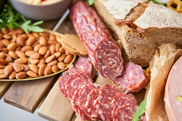 Salami sausage close-up. Table full of mediterranean appetizers, tapas or antipasto. Assorted...