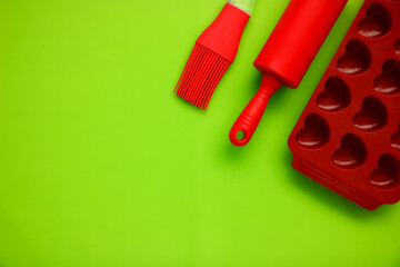 culinary background, culinary spatula, brush, baking dish on a bright green background with copy space