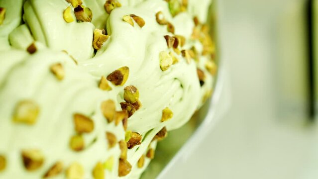 tray with creamy pistachio ice cream topped with pistachio chips, prepared in an ice cream factory