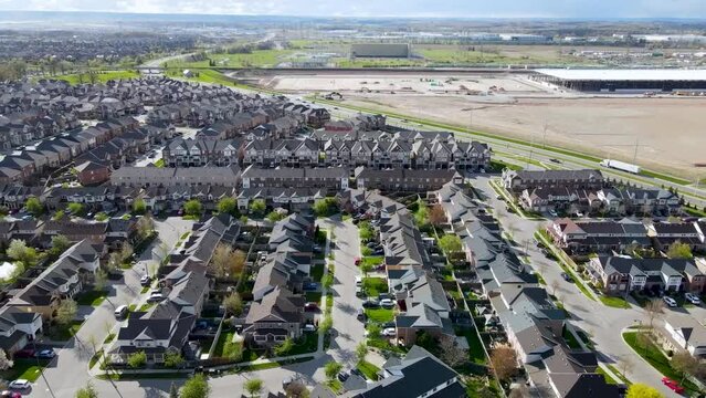 Drone flying up over Milton suburb next to rural farming area.