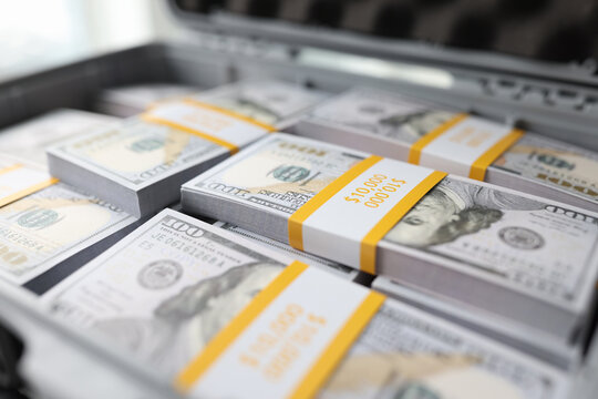 Many stacks of dollar bills in briefcase close up.